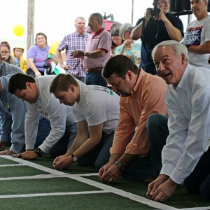 Gov. Asa Hutchinson (second from right) readies his toad for a harem-scarem hop to the finish line at Toad Suck Daze in Conway May 4. Credit Bobby Ampezzan