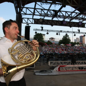 Arkansas Democrat-Gazette/BOBBY AMPEZZAN - 7/4/15 - Dan Vidican tunes up his french horn at the 24th Pops on the River on and around the First Security Amphitheater.